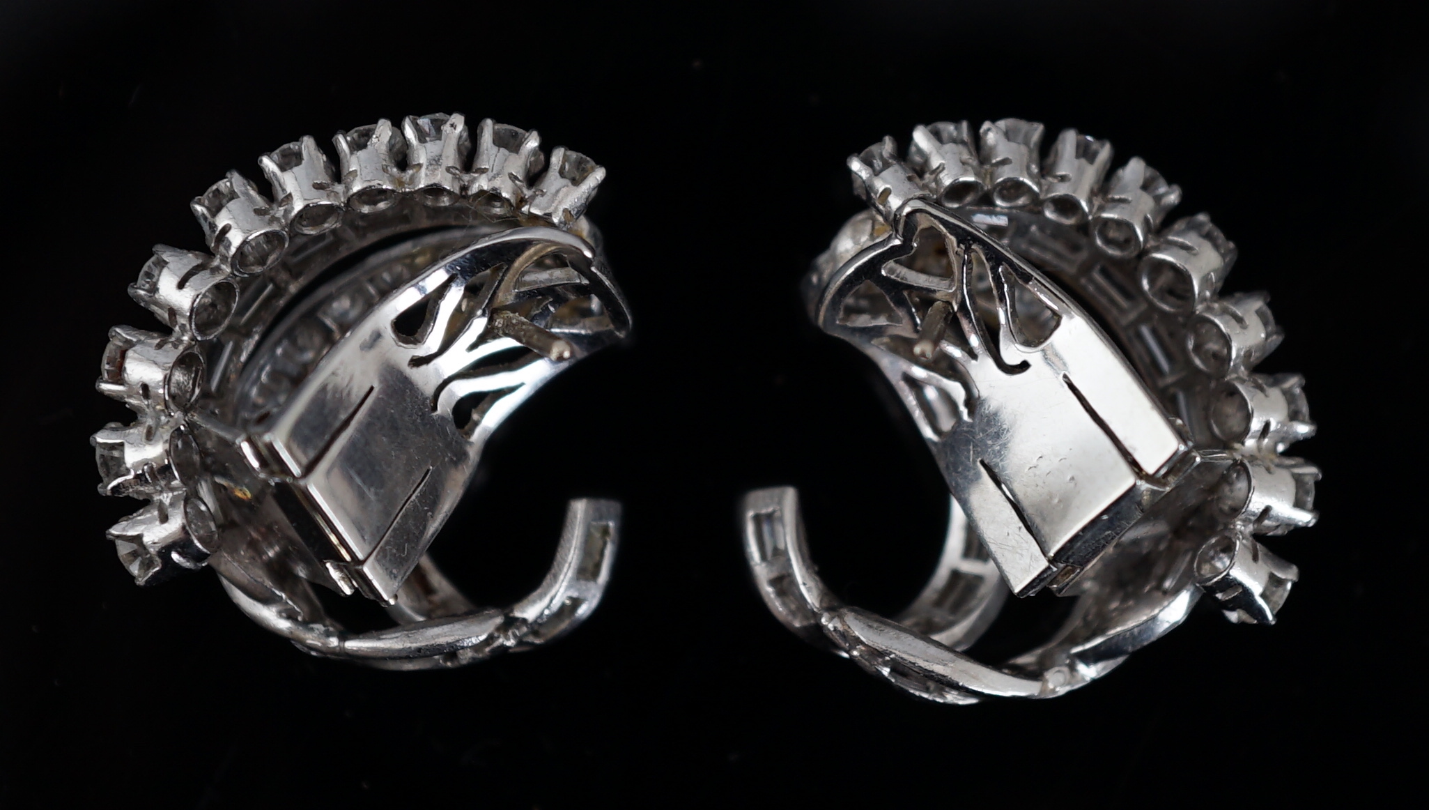 A pair of platinum? and diamond cluster set scrolling earrings